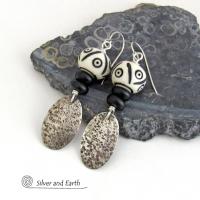 These handcrafted sterling silver earrings have a rustic, hand stamped texture and are accented with African carved bone and matte black agate beads. The bone beads have a bold, striking pattern of black circles and lines carved into a white base. Lightweight and fun to wear - they have an ethnic, tribal vibe and will make a unique statement.