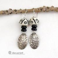 These handcrafted sterling silver earrings have a rustic, hand stamped texture and are accented with African carved bone and matte black agate beads. The bone beads have a bold, striking pattern of black circles and lines carved into a white base. Lightweight and fun to wear - they have an ethnic, tribal vibe and will make a unique statement.