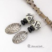 These handcrafted sterling silver earrings have a rustic, hand stamped texture and are accented with African carved bone and matte black agate beads. The bone beads have a bold, striking pattern of black circles and lines carved into a white base. Lightweight and fun to wear - they have an ethnic, tribal vibe and will make a unique statement.