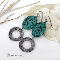 These handcrafted earrings feature natural African turquoise stones accented with silver tone pewter dangles with a hand stamped texture and oxidized finish. They have an earthy, modern style with a touch of southwestern flair. They have a coordinating necklace that is sold separately. Handmade in the USA by Silver and Earth Jewelry. 
