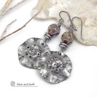 These handcrafted earrings have a bold edgy vibe. They feature rustic hammered silver tone pewter dangles accented with natural asteroid jasper stones and stainless steel beads. This type of stone is known for its unique dotted matrix in earth-tone hues of brown, gray and tan. Bold and striking - they're sure to make a statement. Perfect for women that love unique natural stones and artisan handmade jewelry. Handmade in the USA by Silver and Earth Jewelry. 