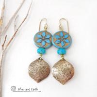 These handcrafted earrings feature gold brass dangles with a lightly hammered raw silk texture accented with glass flower beads and turquoise stone beads. The flower beads are a pretty shade of blue with golden highlights. They have an intricate carved and raised pattern on both sides of the beads. These earrings have a modern elegant, earthy chic style and will make a great gift for anyone that loves flowers and nature. They'll make a great addition to your spring / summer wardrobe - or any time of year.