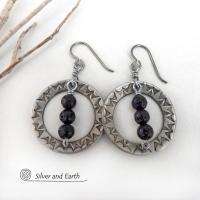 These handcrafted silver pewter hoop earrings have a hand stamped texture accented with black lava rock stones dangling in front. The stones have natural "pits" and crevices which is expected with porous lava stones. Lava stone is formed when molten rock erupts from an active volcano and comes in contact with the cool atmosphere of the Earth, which begins to solidify it. They have an earthy chic style that coordinates with all wardrobe types.