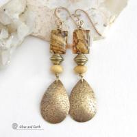 These handcrafted earrings feature gold brass teardrop dangles with a lightly hammered organic texture accented with natural picture jasper stones, brass and fossilized beige coral beads. They have an earthy natural style that coordinates beautifully with all wardrobe styles. Earrings have a coordinating necklace sold separately. Handmade in the USA by Silver and Earth Jewelry.
