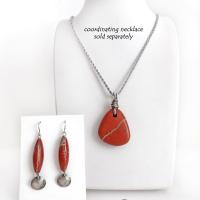 These handmade earrings feature natural red jasper gemstones accented with small hammered sterling silver dangles. The stones have a brick red hue with an interesting matrix of beige streaks and squiggly lines. They have a modern, earthy appeal that coordinates well with all wardrobe styles. They'll make a great gift for a natural stone lover - or a nice addition to your own jewelry wardrobe. They have a coordinating necklace which is sold separately. Handmade in the USA by Silver and Earth Jewelry.  