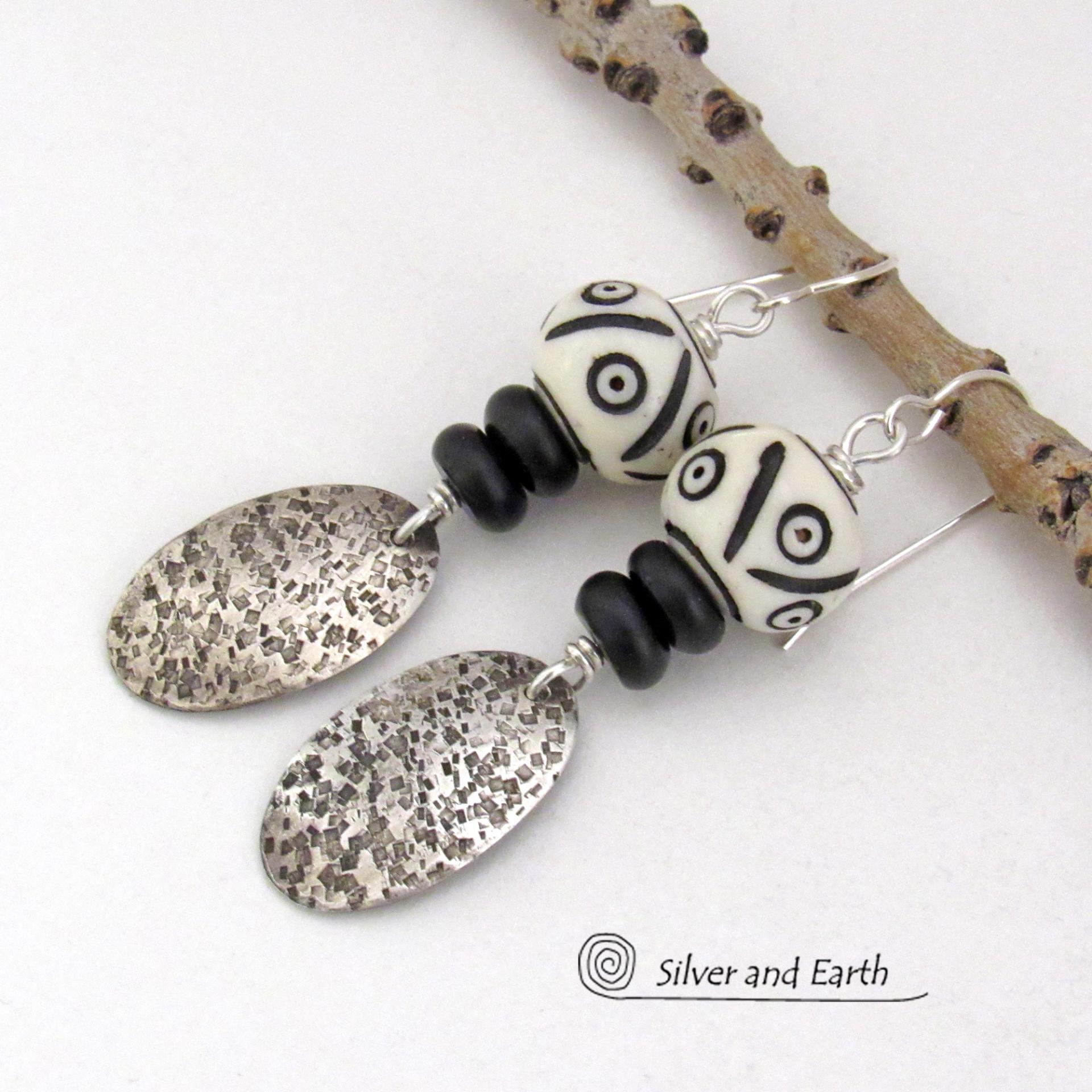 These handcrafted sterling silver earrings have a rustic, hand stamped texture and are accented with African carved bone and matte black agate beads. The bone beads have a bold, striking pattern of black circles and lines carved into a white base. Lightweight and fun to wear - they have an ethnic, tribal vibe and will make a unique statement.