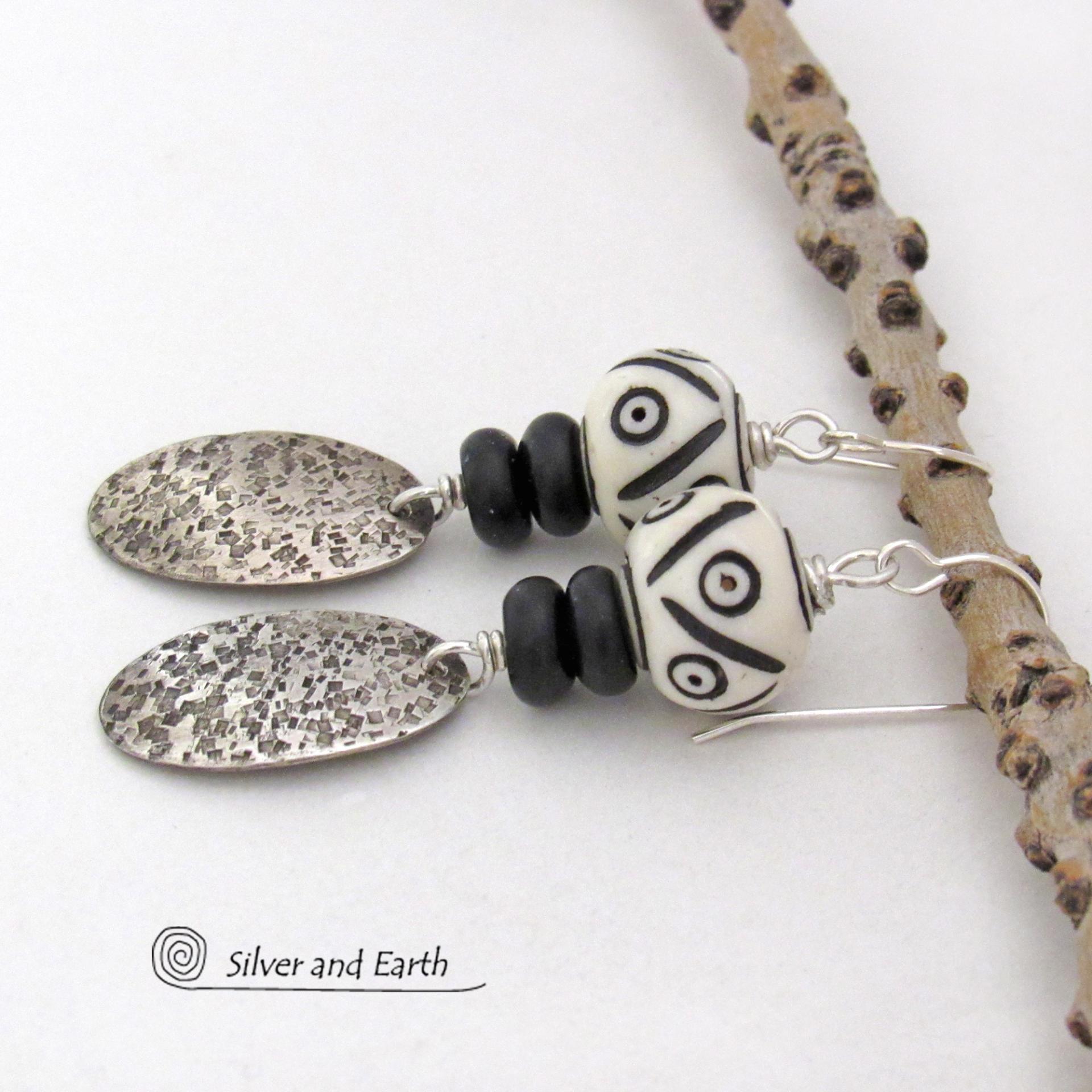These handcrafted sterling silver earrings have a rustic, hand stamped texture and are accented with African carved bone and matte black agate beads. The bone beads have a bold, striking pattern of black circles and lines carved into a white base. Lightweight and fun to wear - they have an ethnic, tribal vibe and will make a unique statement.