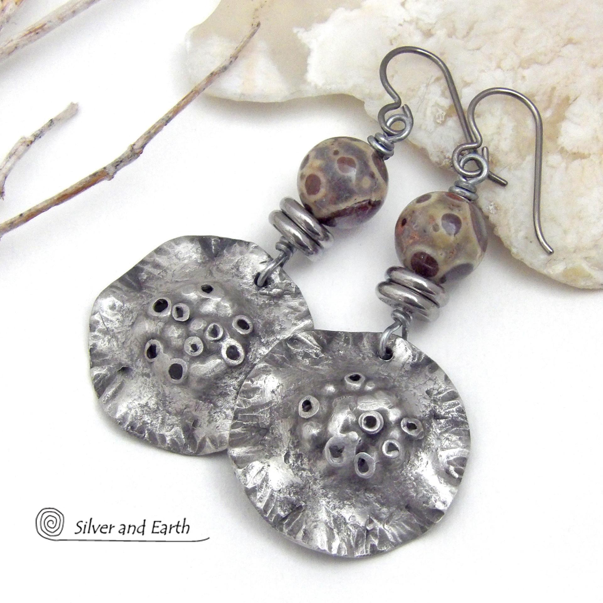 These handcrafted earrings have a bold edgy vibe. They feature rustic hammered silver tone pewter dangles accented with natural asteroid jasper stones and stainless steel beads. This type of stone is known for its unique dotted matrix in earth-tone hues of brown, gray and tan. Bold and striking - they're sure to make a statement. Perfect for women that love unique natural stones and artisan handmade jewelry. Handmade in the USA by Silver and Earth Jewelry. 