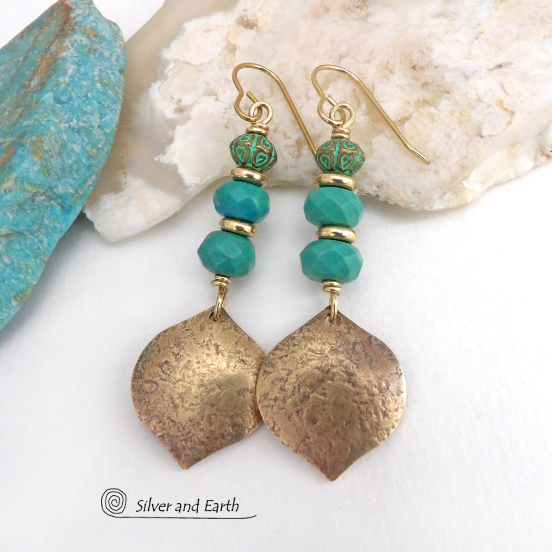 These handcrafted earrings feature gold brass dangles with a hammered organic silky texture accented with faceted genuine turquoise gemstones, tiny brass beads and blue-green patina beads with a tribal style pattern. They have an elegant modern style with a boho chic flair and will make a unique statement. Handmade in the USA by Silver and Earth Jewelry. 