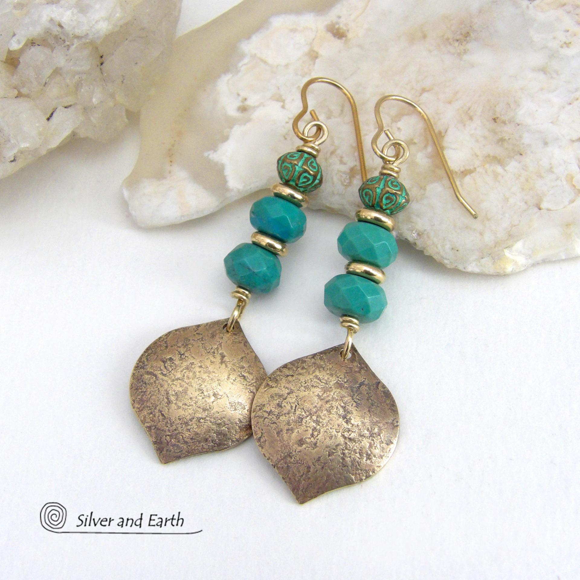 These handcrafted earrings feature gold brass dangles with a hammered organic silky texture accented with faceted genuine turquoise gemstones, tiny brass beads and blue-green patina beads with a tribal style pattern. They have an elegant modern style with a boho chic flair and will make a unique statement. Handmade in the USA by Silver and Earth Jewelry. 