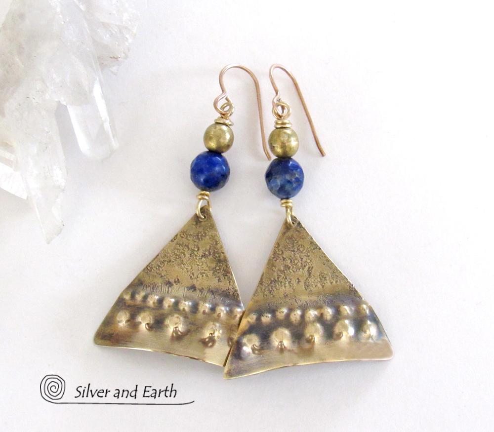 These handcrafted gold brass earrings have an exotic, Egyptian inspired vibe. The design consists of brass dangles with a hand textured design accented with faceted lapis lazuli gemstones and brass beads. Bold and unique - they'll make a striking statement. Perfect for women that love to wear eye-catching jewelry. Handmade in the USA by Silver and Earth Jewelry. 