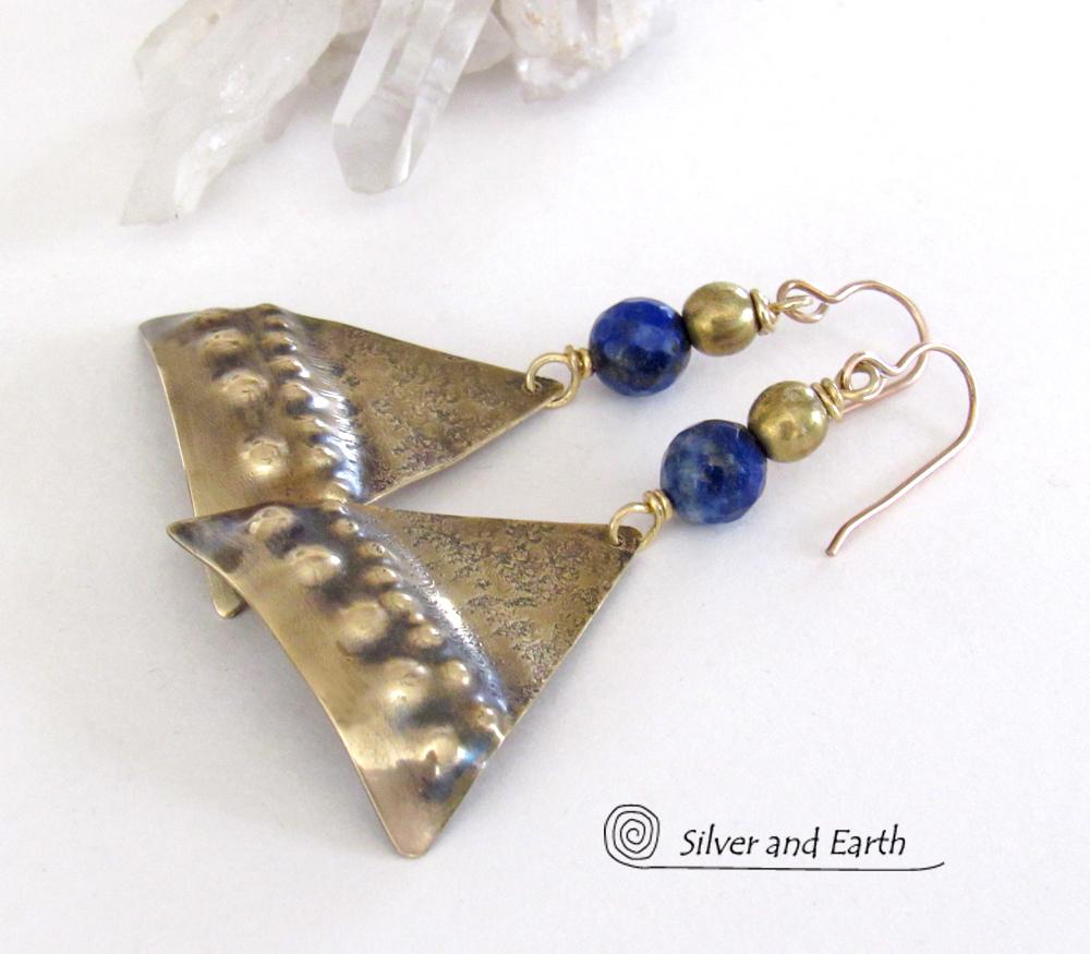 These handcrafted gold brass earrings have an exotic, Egyptian inspired vibe. The design consists of brass dangles with a hand textured design accented with faceted lapis lazuli gemstones and brass beads. Bold and unique - they'll make a striking statement. Perfect for women that love to wear eye-catching jewelry. Handmade in the USA by Silver and Earth Jewelry. 