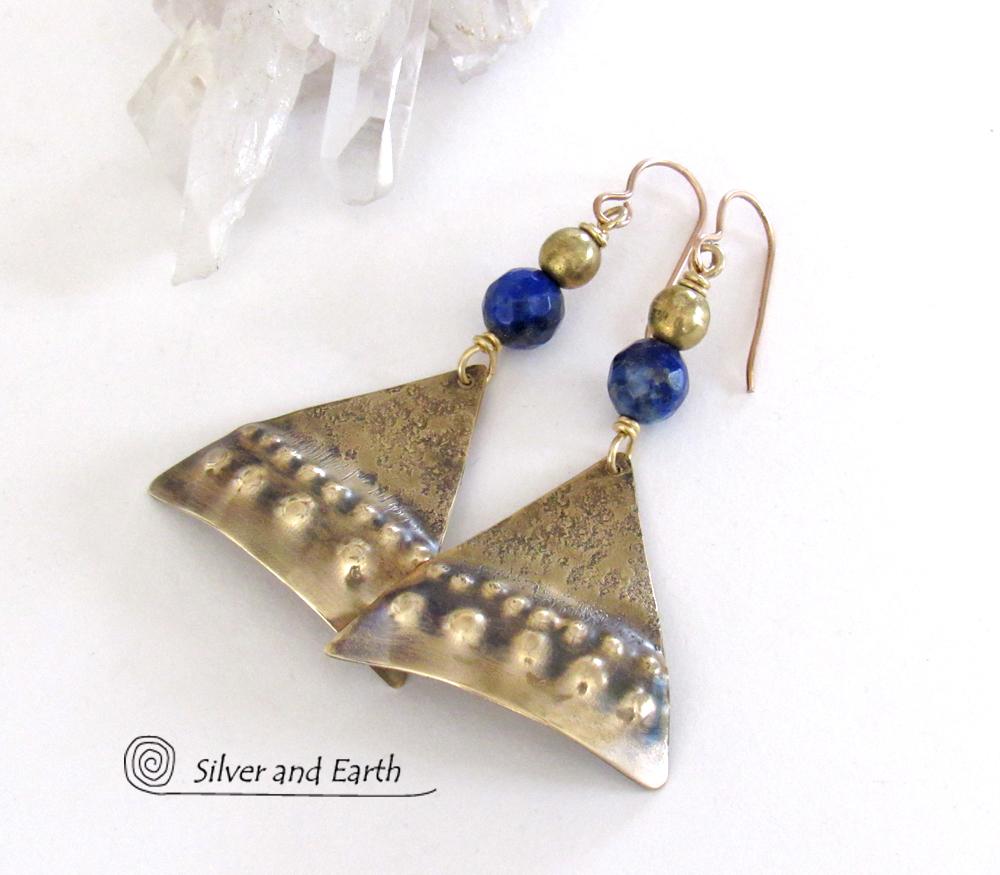 These handcrafted gold brass earrings have an exotic, Egyptian inspired vibe. The design consists of brass dangles with a hand textured design accented with faceted lapis lazuli gemstones and brass beads. Bold and unique - they'll make a striking statement. Perfect for women that love to wear eye-catching jewelry. Handmade in the USA by Silver and Earth Jewelry. 