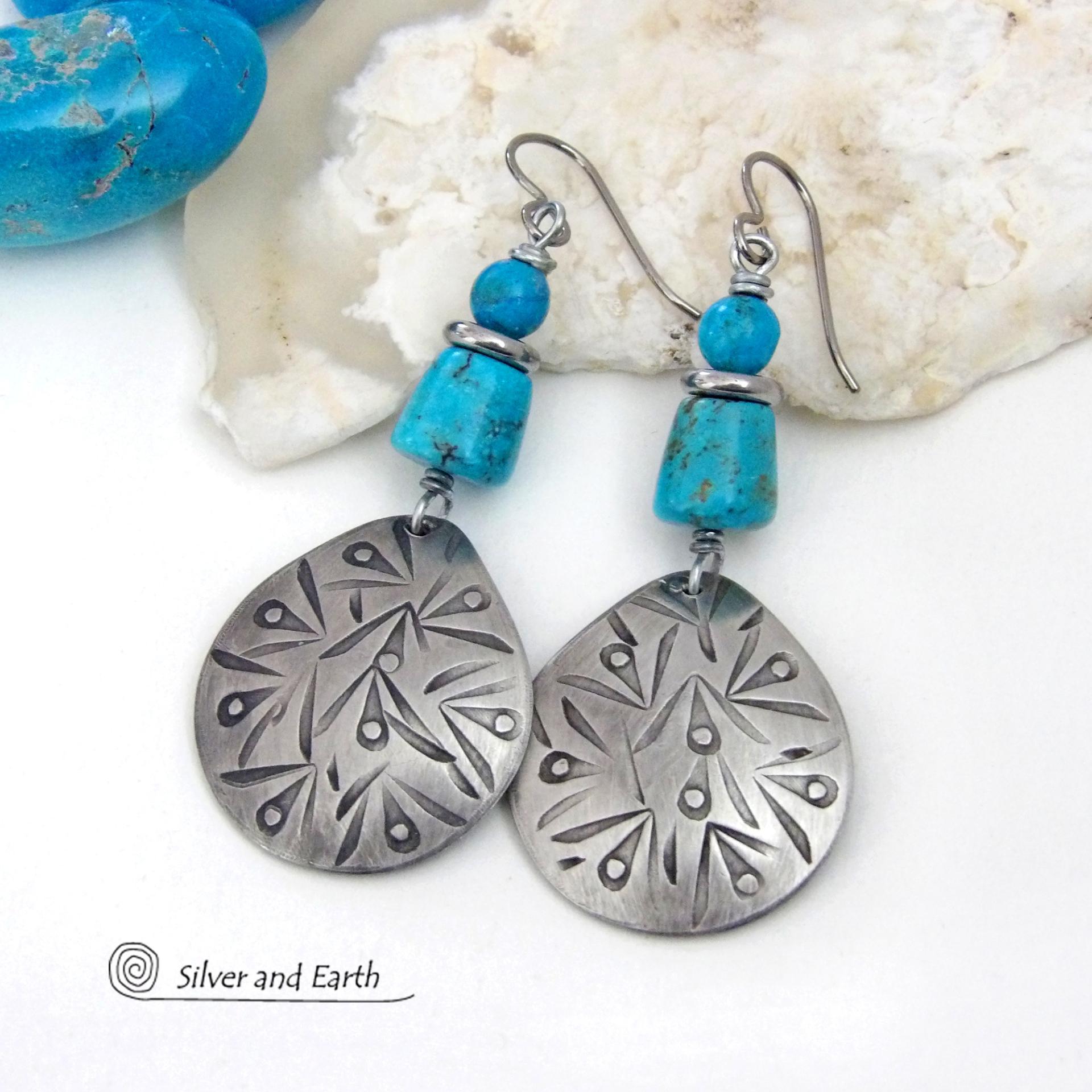 These handcrafted earrings feature silver pewter teardrop-shaped dangles with a hand stamped texture accented with natural turquoise stones and stainless steel spacer beads. They have a bold modern style with southwestern flair and will make a striking statement. They'll make a great gift for anyone that loves natural turquoise stones and southwest style jewelry. Handmade in the USA by Silver and Earth Jewelry, a New Mexico True Certified business. 