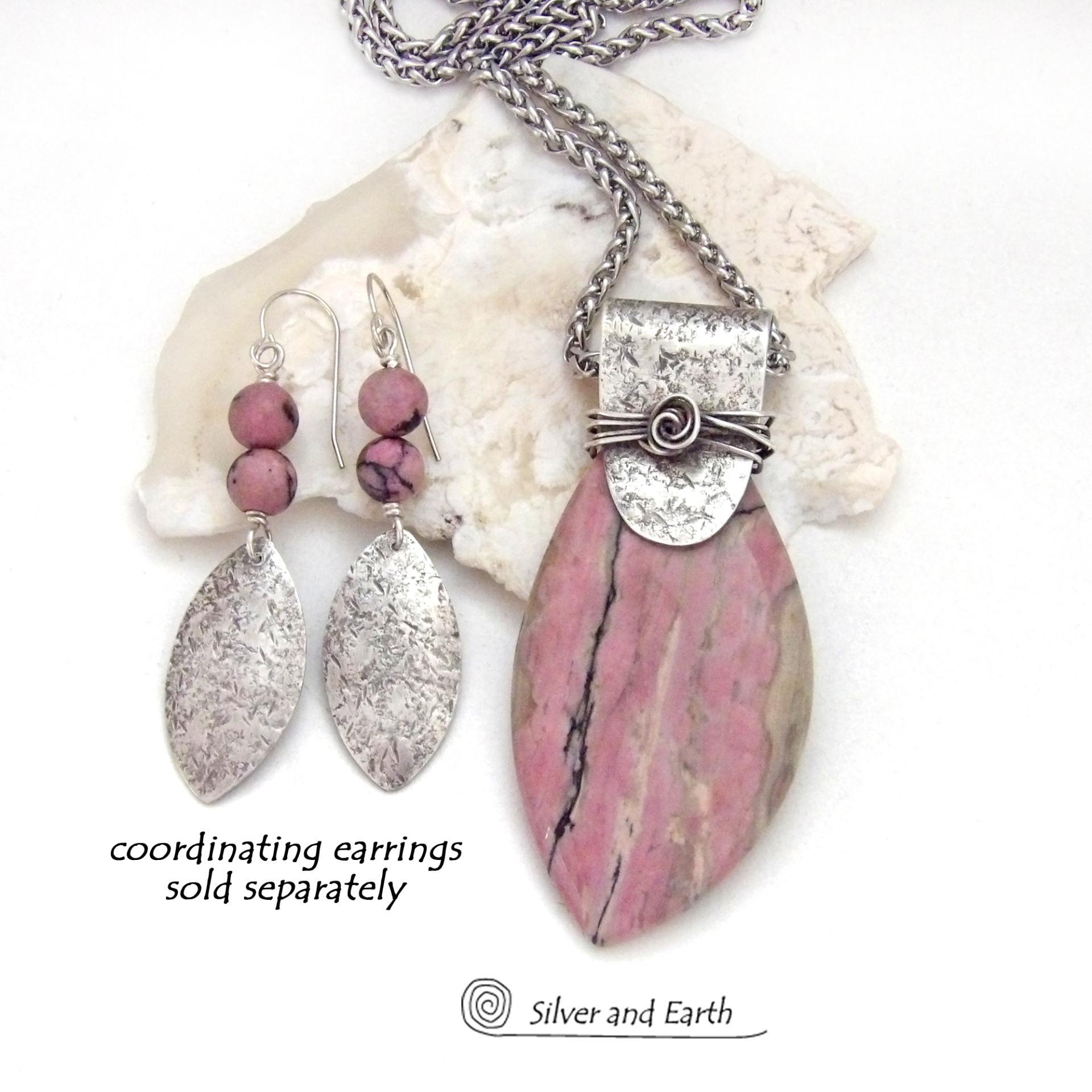 This one-of-a-kind necklace features a large gorgeous rhodonite gemstone accented with a handcrafted sterling silver bail. The stone has a beautiful pink hue with a natural matrix pattern of black, white and tan lines. Coordinating earrings sold separately. Makes a great gift for a natural stone lover - or a nice addition to 