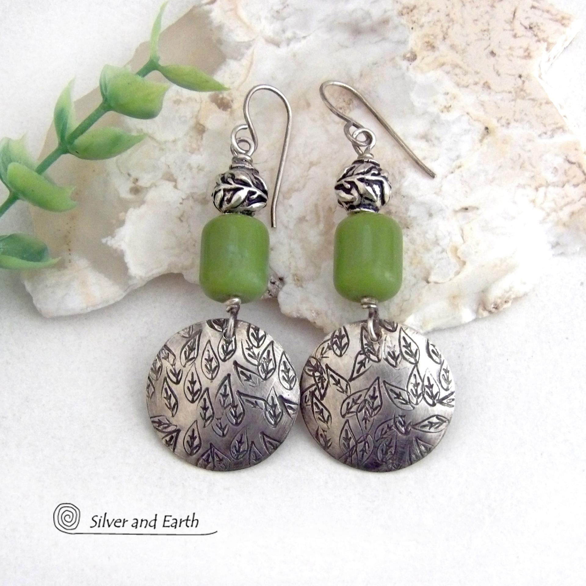 Sterling silver earrings with a hand stamped leaf design accented with natural green serpentine stones and silver pewter beads. The stones have a lime green hue and the pewter beads have a beautifully detailed 3-dimensional carved pattern of vines and leaves. They have a modern, earthy style and will make a great gift for a nature lover.  These artisan-made earrings are perfect for adding a touch of earthy modern style to any outfit. 