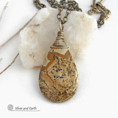 This one-of-a-kind necklace features a natural picture jasper stone wrapped in gold brass wire. The stone has an interesting matrix pattern with earthy hues of brown, tan and black. It has an earthy, simple style that coordinates beautifully with all wardrobe styles. It makes a great gift for a natural stone lover - or a nice addition to your own jewelry collection. Handmade in the USA by Silver and Earth Jewelry. Coordinating earrings sold separately.