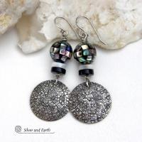These handcrafted sterling silver earrings feature an abstract hand stamped texture and are accented with inlaid abalone shell mosaic, black onyx and mother-of-pearl beads. The abalone beads resemble disco balls and have a beautiful rainbow iridescence of various colors. Bold and unique, they have a modern contemporary style and will make a striking statement. Handmade in the USA by Silver and Earth Jewelry.