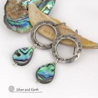 Vibrant natural abalone shells dangle from handcrafted silver pewter hoops in these modern stylish earrings. Each shell has its own unique pattern - with beautiful swirls and streaks of peacock blue, green, purple, silver and charcoal and a lovely iridescent shine. Lightweight and comfortable to wear, they'll look great with all wardrobe styles. 