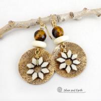 These handmade gold brass earrings have an ethnic bohemian style with an African inspired flair that makes a bold statement. They feature round brass dangles with a lightly hammered texture accented with African flower-shaped bone beads, faceted natural tiger's eye gemstones and African bone beads. Unique and fun to wear, they'll make a great gift for nature lovers and gardeners who love bohemian style jewelry.