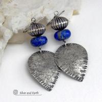 Big and bold - these earrings feature handcrafted sterling silver dangles with a rustic, organic texture accented with chunky natural blue lapis lazuli gemstones and Native style oxidized sterling silver beads with a rich, corrugated texture. They have a modern southwestern and tribal flair that makes a bold statement. Perfect for women that love artisan handcrafted southwest Santa Fe style jewelry. Handmade in the USA by Silver and Earth Jewelry - a New Mexico True Certified Business. 