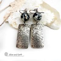 These sterling silver earrings have an earthy, organic and modern contemporary flair. They feature handcrafted sterling silver rectangles with a rustic hammered texture accented with round chunky agate gemstones. The stones have a striking natural matrix of white, gray and black speckles which create a granite-like effect. Unique and one-of-a-kind, they'll make a great gift for women that love bold unique jewelry and natural stones. 