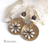 These handmade gold brass earrings have an ethnic bohemian style with an African inspired flair that makes a bold statement. They feature round brass dangles with a lightly hammered texture accented with African flower-shaped bone beads, faceted natural tiger's eye gemstones and African bone beads. Unique and fun to wear, they'll make a great gift for nature lovers and gardeners who love bohemian style jewelry. Handmade in the USA by Silver and Earth Jewelry. 