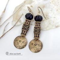 Bold and unique, these handcrafted earrings have an ethnic African tribal vibe. They feature gold brass dangles with a hand stamped and lightly hammered background texture accented with African beads with an intricately carved brownish-black and tan pattern topped off with black African carved bone beads. Unique and fun to wear - they'll make a bold, striking statement. Perfect for women that love to wear one-of-a-kind artisan handcrafted jewelry. Handmade in the USA by Silver and Earth Jewelry.