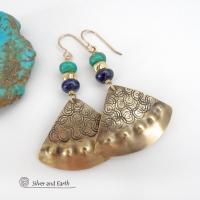 These handcrafted gold brass earrings have an exotic, Egyptian inspired vibe. The design consists of brass fan-shaped dangles with a hand textured design accented with lapis lazuli and turquoise gemstones and gold plated beads. Bold and unique, they'll add a touch of cultural exotic charm to any type of wardrobe. Handmade in the USA by Silver and Earth Jewelry, these earrings are a beautiful and stylish way to add a touch of elegance to any outfit. 
