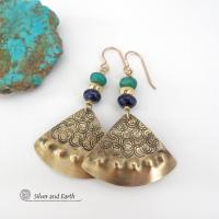 These handcrafted gold brass earrings have an exotic, Egyptian inspired vibe. The design consists of brass fan-shaped dangles with a hand textured design accented with lapis lazuli and turquoise gemstones and gold plated beads. Bold and unique, they'll add a touch of cultural exotic charm to any type of wardrobe. Handmade in the USA by Silver and Earth Jewelry, these earrings are a beautiful and stylish way to add a touch of elegance to any outfit. 