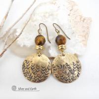 These handcrafted gold brass earrings feature a hand stamped leaf design and are accented with faceted tiger's eye gemstones and brass beads. They have an earthy, modern and elegant style that coordinates beautifully with all wardrobe types. They'll make a great gift for a nature lover - or a nice addition to your own jewelry wardrobe. These artisan-made earrings are perfect for adding a touch of earthy modern style to any outfit. 