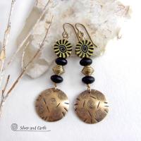 These handcrafted earrings have an ethnic boho tribal vibe. They feature gold brass dangles with a hand stamped spiral and line texture accented with black and light yellow Fimo clay beads with a spiral design, black glass and brass beads. Unique and fun to wear - they have a funky bohemian vibe that makes a bold, striking statement. Perfect for women that love to wear one-of-a-kind artisan handcrafted jewelry. Handmade in the USA by Silver and Earth Jewelry. 
