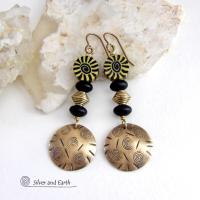 These handcrafted earrings have an ethnic boho tribal vibe. They feature gold brass dangles with a hand stamped spiral and line texture accented with black and light yellow Fimo clay beads with a spiral design, black glass and brass beads. Unique and fun to wear - they have a funky bohemian vibe that makes a bold, striking statement. Perfect for women that love to wear one-of-a-kind artisan handcrafted jewelry. Handmade in the USA by Silver and Earth Jewelry. 
