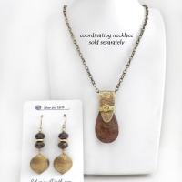 These handcrafted earrings feature gold brass dangles with a hammered organic texture accented with natural bronzite gemstones and shiny gold brass beads. The stones have a beautiful brown hue with a faceted finish which casts off a natural sparkle and shine. They have a modern chic style that coordinates beautifully with all wardrobe types - dressed up or down. A coordinating necklace is available that is sold separately.  Handmade in the USA by Silver and Earth Jewelry.