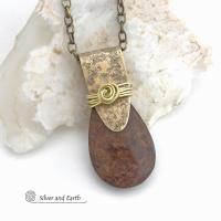 This handcrafted necklace features a natural bronzite gemstone accented with a gold brass bail. The stone has a beautiful chocolate brown hue with a subtle golden shimmer. Bronzite is a mineral that shares characteristics with rock that is found in meteorites, such as iron. It's this blend of several minerals which gives bronzite its unique mottled characteristic. The necklace has an earthy, modern style that coordinates beautifully with all wardrobe types. 