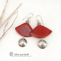 These one-of-a-kind earrings feature carnelian gemstones carved into unique fan-shaped "slices" accented with small hammered sterling silver dangles and textured silver beads. The stones have a a deep rusty orange hue with a  translucent luster. Bold and striking, they'll make a unique statement.