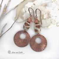 These handcrafted copper earrings have a bold, ethnic African style and flair. They feature round copper dangles with a rustic hammered texture accented with African etched giraffe print agate stones topped off with solid copper beads. Unique and striking, they'll make a bold statement. Handmade in the USA by Silver and Earth Jewelry. 