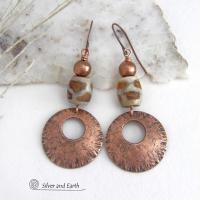 These handcrafted copper earrings have a bold, ethnic African style and flair. They feature round copper dangles with a rustic hammered texture accented with African etched giraffe print agate stones topped off with solid copper beads. Unique and striking, they'll make a bold statement. Perfect for women that love ethnic tribal style jewelry. Your choice of ear wire - copper or hypoallergenic niobium.