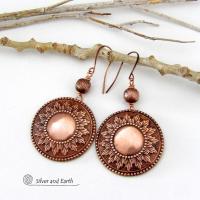 These handcrafted copper earrings have a beautifully detailed embossed sun medallion texture with an oxidized finish and are accented with brushed satin copper beads. Big and bold, they'll make a striking statement. Unique and versatile, they are lightweight and comfortable to wear and will look great with all wardrobe styles. Handmade in the USA by Silver and Earth Jewelry.