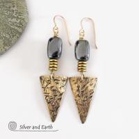 These gold brass triangle earrings have a hand stamped texture and are accented with natural hematite nugget-shaped gemstones on top of a stack of tiny brass beads. They have a modern contemporary and edgy style that makes a bold statement.
