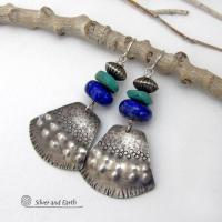 Bold and striking, these handcrafted earrings feature uniquely textured sterling silver accented with natural turquoise and lapis gemstones. They are topped off with Native style oxidized sterling silver beads with a rich, corrugated texture. They have a modern southwestern flair and are perfect for women that love to wear one-of-a-kind artisan handcrafted jewelry. Handmade in the USA by Silver and Earth - a New Mexico True Certified business.