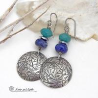 These handcrafted earrings feature sterling silver dangles with a hand stamped texture accented with faceted turquoise and lapis lazuli gemstones. Small hematite gemstones with a faceted finish were added for a touch of natural sparkle and shine. The earrings have a contemporary, modern chic style with a bit of southwestern flair. They'll coordinate beautifully with all wardrobe types - dressed up or down. Handmade in the USA by Silver and Earth Jewelry. 