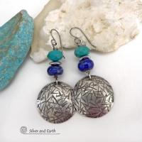These handcrafted earrings feature sterling silver dangles with a hand stamped texture accented with faceted turquoise and lapis lazuli gemstones. Small hematite gemstones with a faceted finish were added for a touch of natural sparkle and shine. The earrings have a contemporary, modern chic style with a bit of southwestern flair. They'll coordinate beautifully with all wardrobe types - dressed up or down. Handmade in the USA by Silver and Earth Jewelry. 