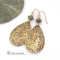 These handcrafted gold brass teardrop earrings have a hand stamped texture and are accented with natural silver pyrite gemstone beads. They have a modern contemporary style that coordinates beautifully with all wardrobe types.  MEASUREMENTS: Total length: 2-3/8” from top of bronze ear wires and 1” at widest point. Created out of solid gold brass; the shapes were hand stamped for texture; oxidized to enhance the detail. Handmade in the USA by Silver and Earth Jewelry.