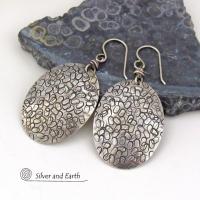 These handmade sterling silver earrings are unique and versatile. Perfect for everyday wear, they go with everything. They have a modern design with a hand stamped texture and an oxidized finish.