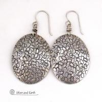 These handmade sterling silver earrings are unique and versatile. Perfect for everyday wear, they go with everything. They have a modern design with a hand stamped texture and an oxidized finish.