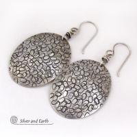 These handmade sterling silver earrings are unique and versatile. Perfect for everyday wear, they go with everything. They have a modern design with a hand stamped texture and an oxidized finish.
