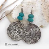 These handcrafted earrings feature large sterling silver round dangles with a hand stamped texture accented with natural turquoise gemstones with a faceted finish. Big and bold, they have a modern style with southwestern flair that looks great with all wardrobe types. Perfect for women that love large earrings and bold statement jewelry. Handmade in the USA by Silver and Earth Jewelry, a New Mexico True Certified business.