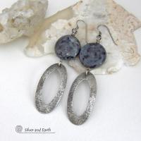 Modern, earthy & chic - these earrings feature big round natural larvikite gemstones accented with long sterling silver hoop dangles. The stones have a pearly, grayish black hue - along with blue iridescent flashes of light which cast off a natural shimmer & shine. They have a modern, contemporary style that coordinates beautifully with all wardrobe types. Larvikite originates from the Larvik region in Norway and is also called Norwegian moonstone and black labradorite. 