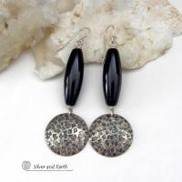 These handcrafted sterling silver dangle earrings have a hand stamped texture and oxidized finish and feature long black onyx gemstones. The stones are cut into a unique, elongated tubular shape and have a rich black hue and high polish. They have a modern, contemporary style that will look great with all wardrobe types. 